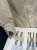 Close-up of a brown-beige shirt with fabric swatches underneath