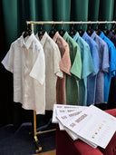 Row of short-sleeve shirts on hangers with a magazine titled 'SU MISURA' in the foreground.