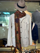 Mannequin wearing a beige jacket, patterned scarf, and hat in a store setting.