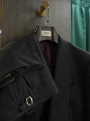 Black coat and trousers hanging on WH Bespoke hanger