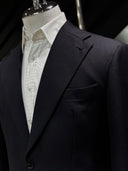 Black suit jacket on a mannequin with a white shirt underneath